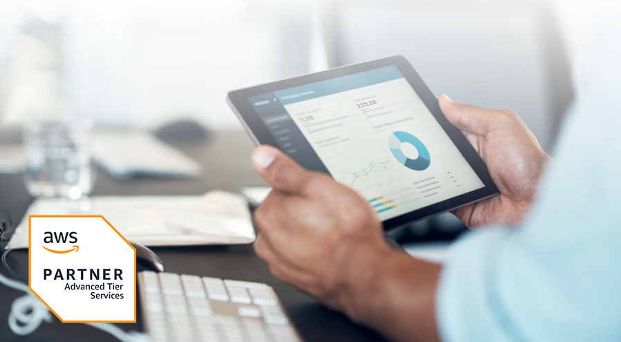 Image of a business professional looking at metrics on an app dashboard on a tablet. The image also features an AWS partner advanced tier services badge.